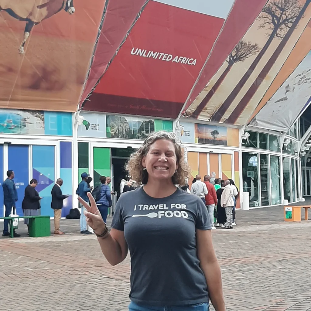woman standing in front of a sign that says unlimited africa