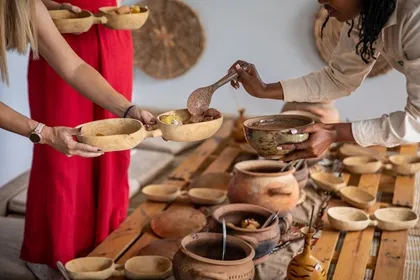 serving food from traditional dishes at a table in rwanda